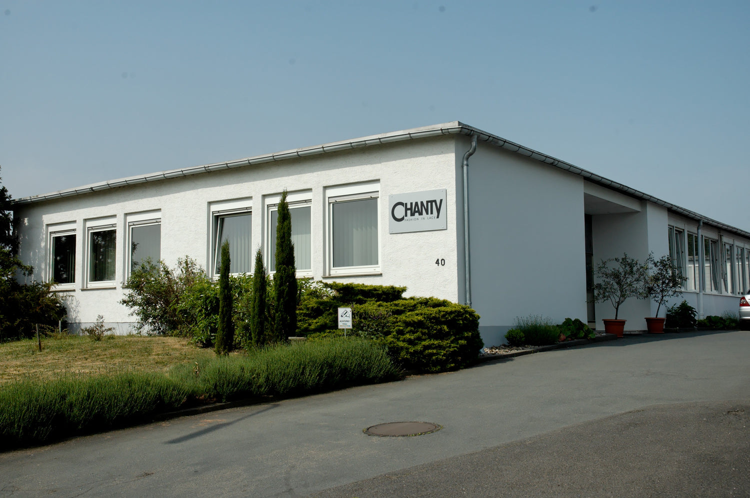CHANTY Gebäude mit Grünfläche und Parkplatz