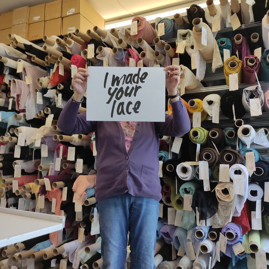 Person holding up sign saying I made your lace sample room