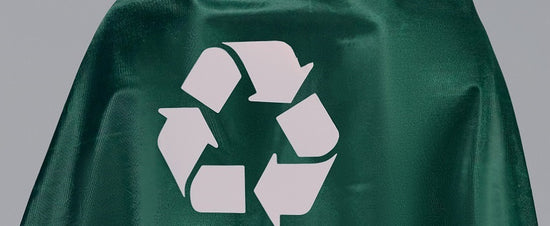 A woman with a cape with the recycling symbol on it